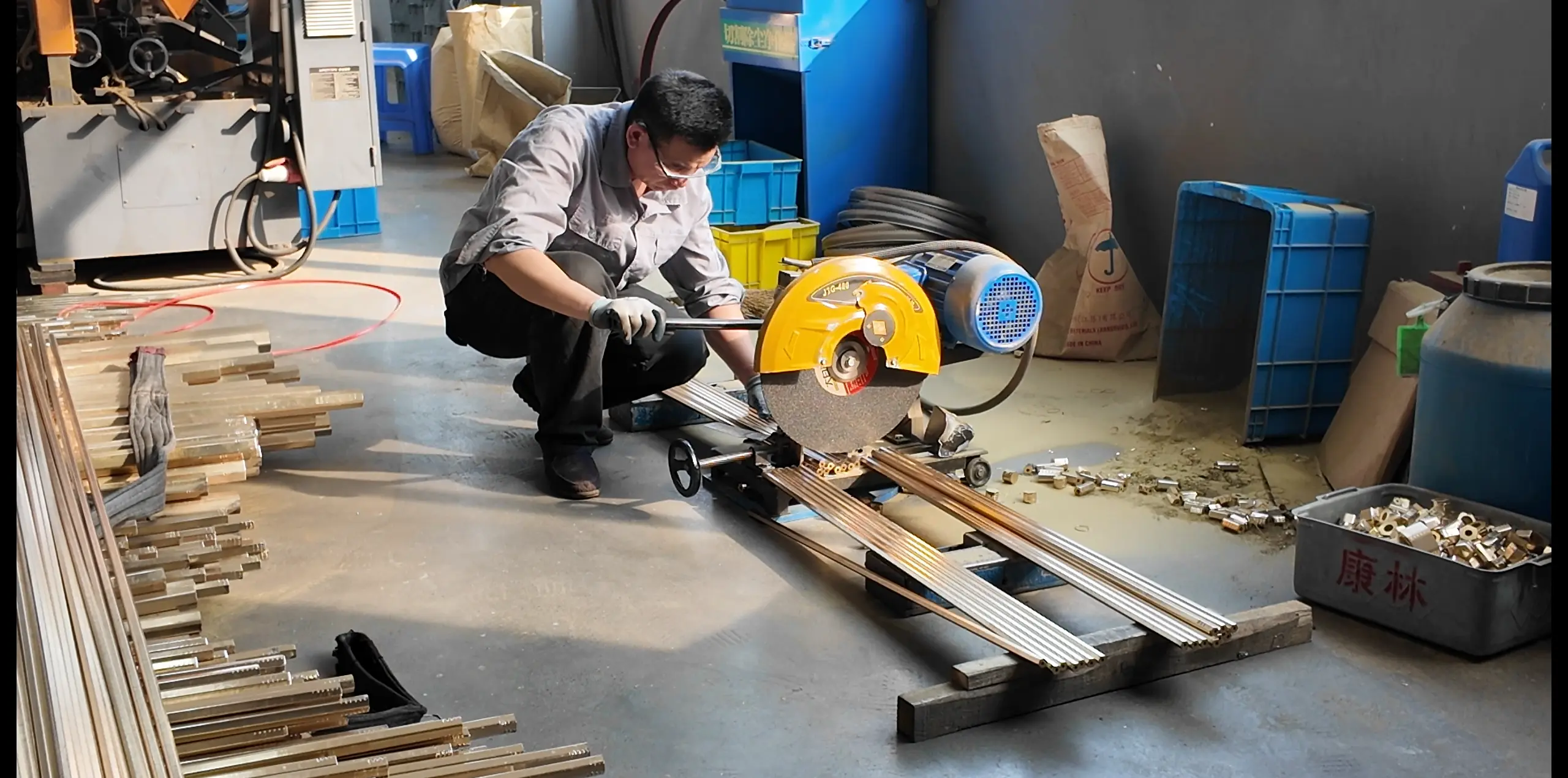 engineer cutting copper tubes in terminal manufacturing workshop, industrial electrical connector production process